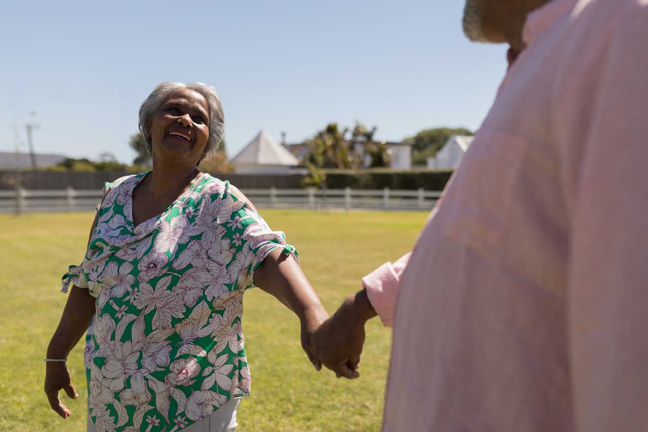 elderly woman and man holding hands and dancing with each other